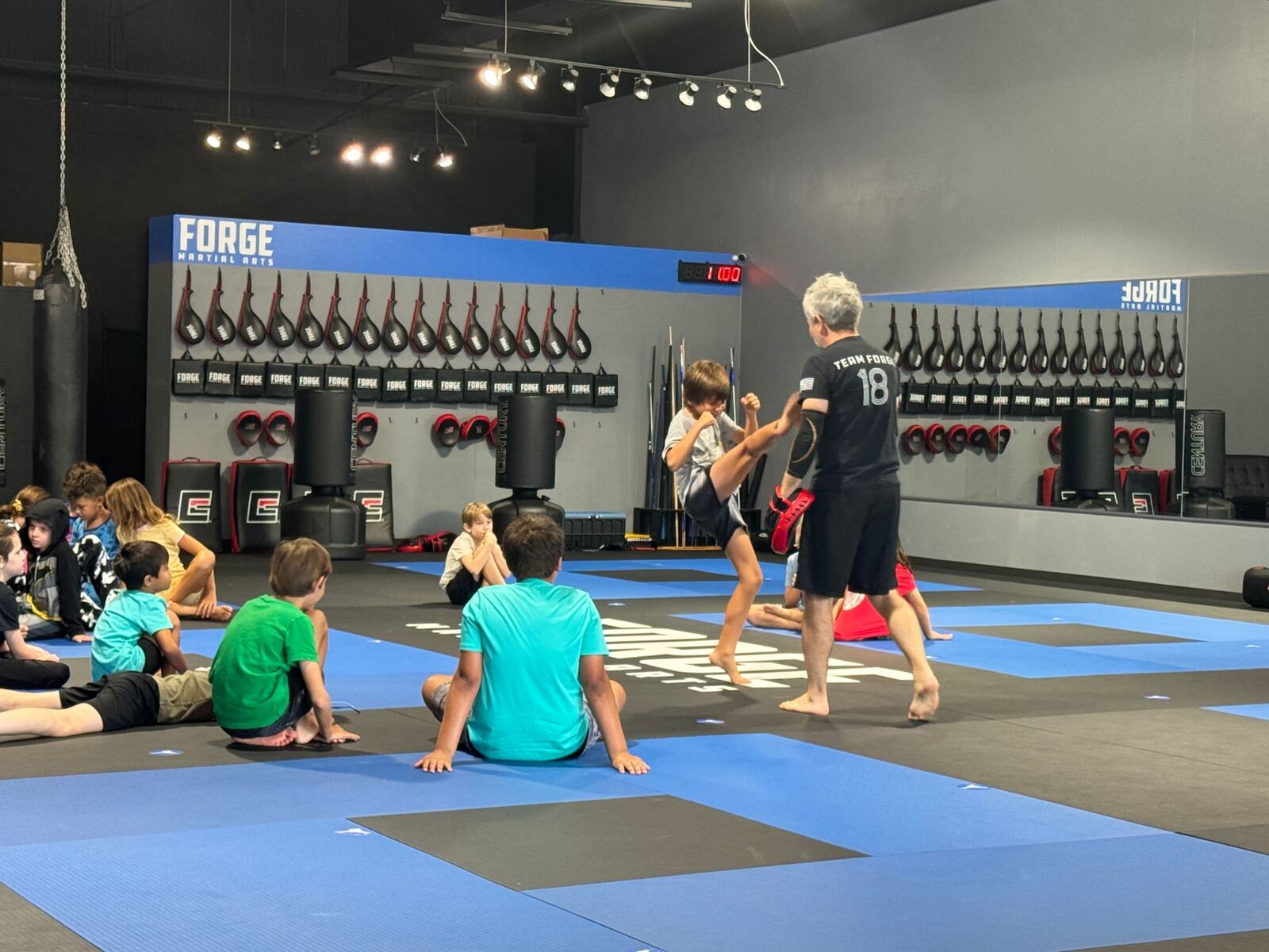 Camper kicking pads with instructor